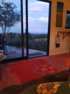 a room with a large glass door with a view at Hapuku River Terrace a Eco Tiny House escape in Kaikoura