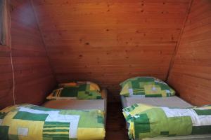 two beds in a small room with wooden walls at Domki Lazur in Jastrzębia Góra