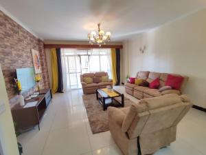 - un salon avec deux canapés et une télévision dans l'établissement Lux Suites Skyhorse Apartments Kilimani, à Nairobi