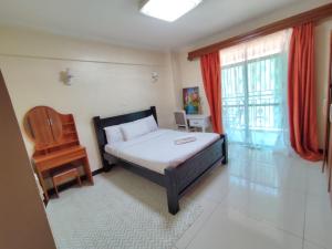 sypialnia z łóżkiem, krzesłem i oknem w obiekcie Lux Suites Skyhorse Apartments Kilimani w mieście Nairobi