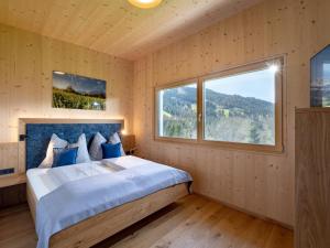 ein Schlafzimmer mit einem großen Bett und einem großen Fenster in der Unterkunft Apartment sZuahäusl in Ellmau