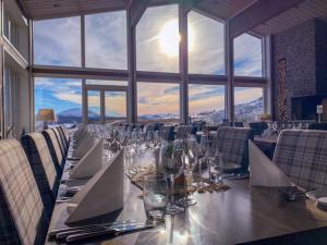 a long table in a room with a large window at Brimi Fjellstugu in Fluguhaug