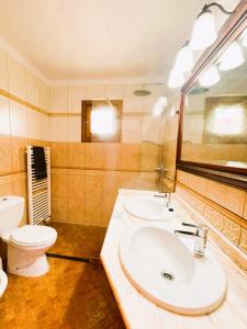 a bathroom with two sinks and a toilet at Finca Ceguer MHM in Font de Sa Cala