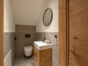 bagno con lavandino, servizi igienici e specchio di Apartment sZuahäusl a Ellmau