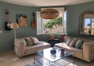 a living room with two couches and a glass table at Plein centre de Beaulieu in Beaulieu-sur-Mer