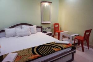 um quarto com uma cama, uma mesa e cadeiras em Goroomgo Muskan Guest House Digha em Digha