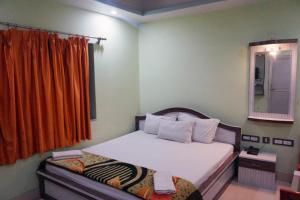 um pequeno quarto com uma cama e um espelho em Goroomgo Muskan Guest House Digha em Digha