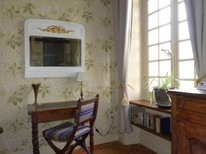 a room with a desk with a chair and a mirror at Demeure de Maugé in Saint-Léger-de-Montbrillais