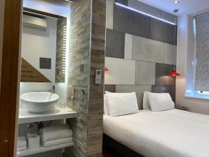 a bathroom with a large bed and a sink at RIOSHOUSE Henley in Henley on Thames