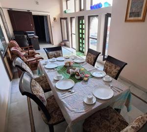 a dining room table with chairs and a tableclotholitics at Sun Heritage Home in Udaipur