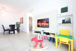 依斯干達公主城的住宿－Afiniti Residensi Legoland Medini，客厅配有桌子和五颜六色的椅子