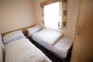 Giường trong phòng chung tại Brilliant 6 Berth Caravan Steeple Bay Holiday Park, Essex Ref 36079d