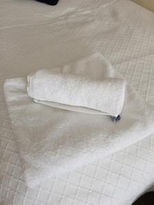 una pila de toallas blancas en una cama en Byways Serviced Apartments, en Salisbury