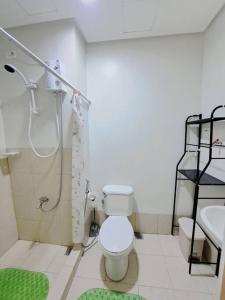 a bathroom with a shower and a toilet and a sink at Condo unit up to 10 pax - with Netflix and Boardgames in Manila
