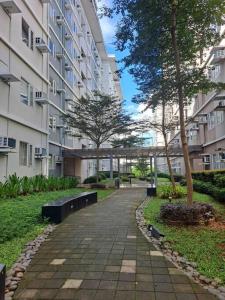 a walkway in a park next to a building at Condo unit up to 10 pax - with Netflix and Boardgames in Manila