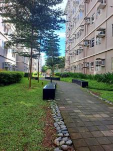 a park with two benches in front of a building at Condo unit up to 10 pax - with Netflix and Boardgames in Manila