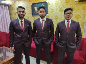 een groep van drie mannen in pakken en dassen bij DAS HOTEL in Darjeeling