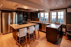 a kitchen with a large island with a stainless steel refrigerator at Storsten 730 in Trysil