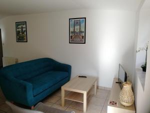 ein Wohnzimmer mit einem blauen Sofa und einem Tisch in der Unterkunft gite de la basse pierre près d'Ancenis Loire in Ancenis