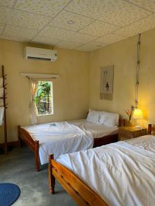 um quarto com 2 camas, uma janela e um tecto em Mango House Retreat Quy Nhon em Quy Nhon