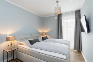 a bedroom with a white bed and a window at Sturmfrei Suite 8 in Scharbeutz