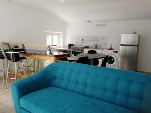 ein Wohnzimmer mit einem blauen Sofa und einer Küche in der Unterkunft gite de la basse pierre près d'Ancenis Loire in Ancenis