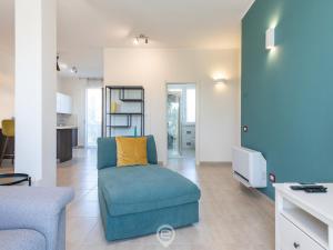 un salon avec une chaise bleue et une télévision dans l'établissement La Palma Chic Apartment, à Cagliari