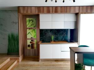 a kitchen with white cabinets and a fish tank at Jacuzzi Apartment in Baia Mare