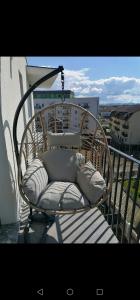 uma cadeira de vime em cima de uma varanda em Jacuzzi Apartment em Baia Mare