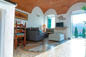 a living room with a couch and a tv at Villa Musso by Tempovacanza in Molino Nuovo