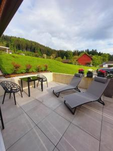 eine Terrasse mit 2 Stühlen und einem Tisch auf der Terrasse in der Unterkunft Ferienhaus Sandra in Hörbranz