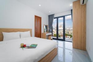 a bedroom with a white bed and a large window at Haphan Hotel And Apartment in Danang