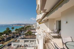 a balcony with chairs and a view of the ocean at Buckingham & Lloyds - Cannes in Cannes