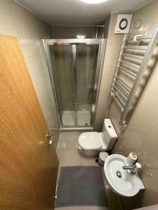 La petite salle de bains est pourvue d'une douche et de toilettes. dans l'établissement Beautiful private detached 1 bed with private outdoor space, à Stone Grove