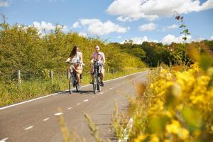 Chaam的住宿－RCN de Flaasbloem，骑着自行车的男人和女人