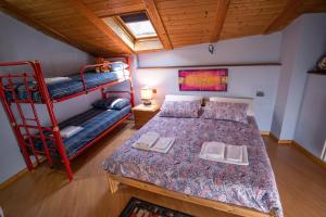 a bedroom with a bed and a bunk bed at Casetta Zoe - Private Sauna in Margone