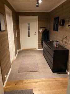 pasillo con puerta y suelo con alfombra en Hytte på fjellet en Håra