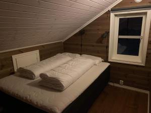een bed in een kamer met een raam bij Hytte på fjellet in Håra