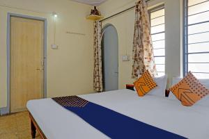 um quarto com duas camas e uma porta com cortinas em SPOT ON Hotel Prakash Residency, Near Hanuman Gym Ajmera Colony, Pimpri em Chinchwad
