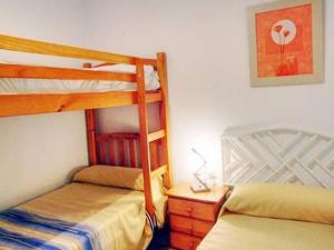 1 dormitorio con 2 literas y escritorio con lámpara en Chalet Merkal en Chiclana de la Frontera
