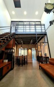 uma sala de estar com uma escada em espiral e uma mesa em [New!] Jonker Street Loft 3BR Melaka 10PAX em Malaca