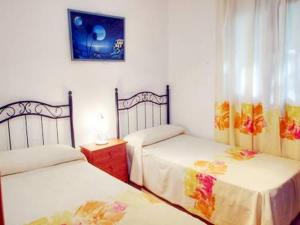 1 dormitorio con 2 camas y una foto en la pared en Chalet Merkal, en Chiclana de la Frontera