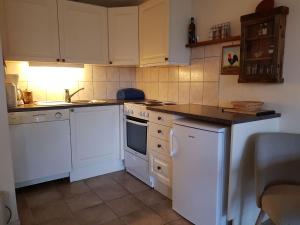 una cocina con armarios blancos y electrodomésticos blancos en Bergland apartment 15 - close to the center of Kragerø, en Kragerø