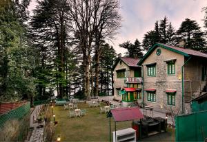 a large house with a yard with tables and chairs at Brij Villa, Dalhousie - A Colonial Luxury Retreat in Dalhousie