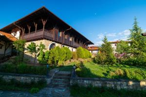 - un grand bâtiment avec un balcon au-dessus d'une cour dans l'établissement Rachev Hotel Residence, à Arbanasi