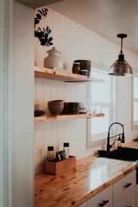 a kitchen with wooden floors and shelves and a sink at The Shasta Cottage in Klamath Falls