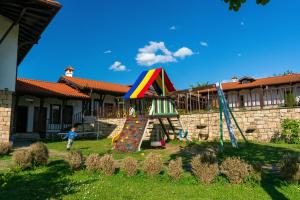 a child standing in a yard with a playground at Rachev Hotel Residence in Arbanasi