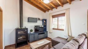 ein Wohnzimmer mit einem Sofa und einem TV in der Unterkunft Casa Tortela Almáchar by Ruralidays in Almáchar
