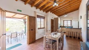 eine Küche und ein Esszimmer mit Tisch und Stühlen in der Unterkunft Casa Tortela Almáchar by Ruralidays in Almáchar