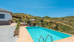 a villa with a swimming pool and a mountain at Casa Tortela Almáchar by Ruralidays in Almáchar